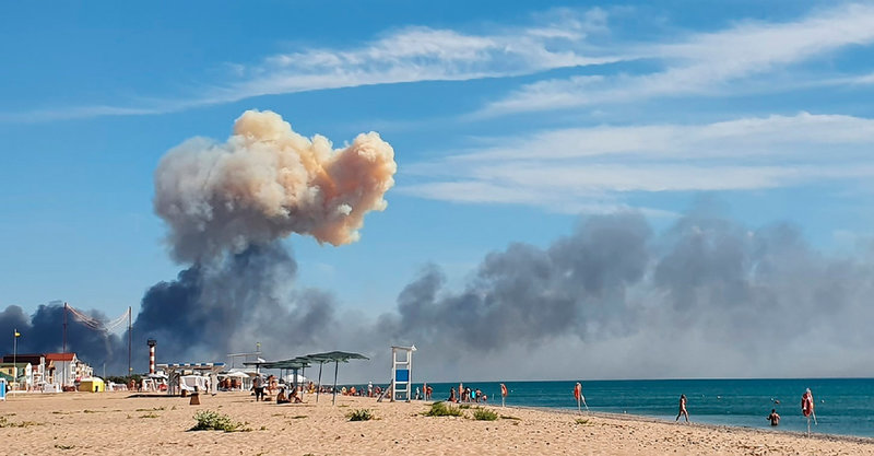 En rökpelare stiger bortom en strand på den annekterade Krimhalvön den 9 augusti. Smällar som dånade i området tros ha orsakats av ukrainsk beskjutning mot en rysk flygbas. Arkivbild.