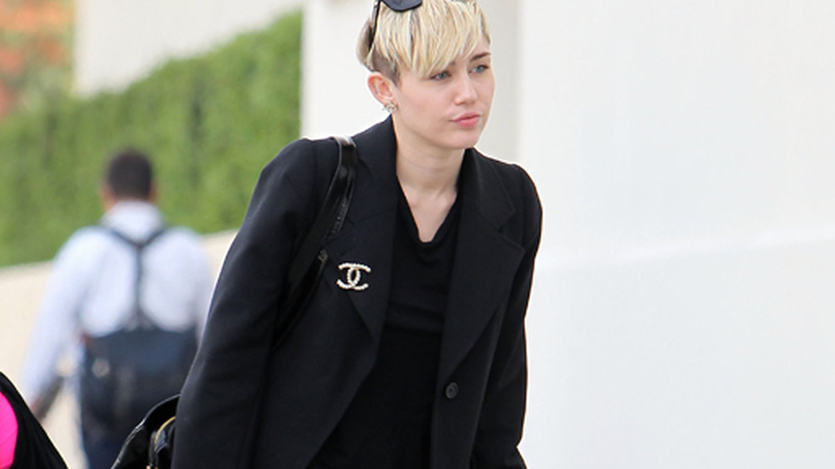 Miley Cyrus rockar svarta sneakers med platå. 