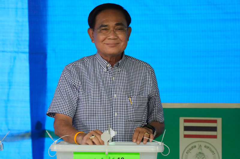 Premiärminister Prayut Chan-O-Cha, ledare för det nybildade partiet Ruam Thai Sang Chart, poserar för kamerorna när han röstar i Bangkok.