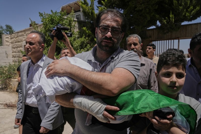 Fahd Abu Haikal, 41, bär sin son i samband med begravningen i Hebron på lördagen.