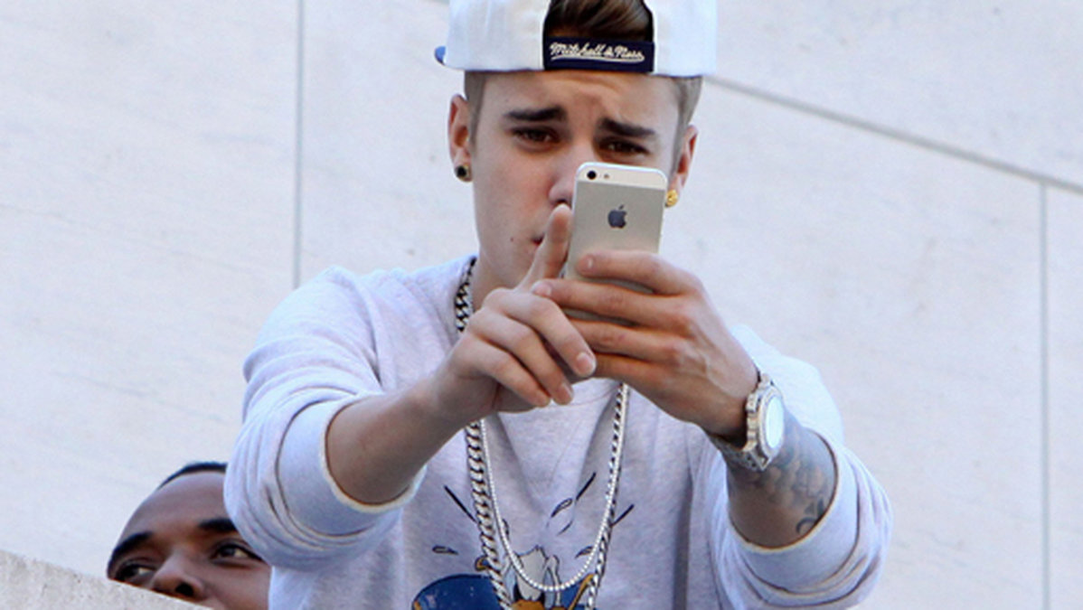 Justin Bieber är glad i sin iPhone. 