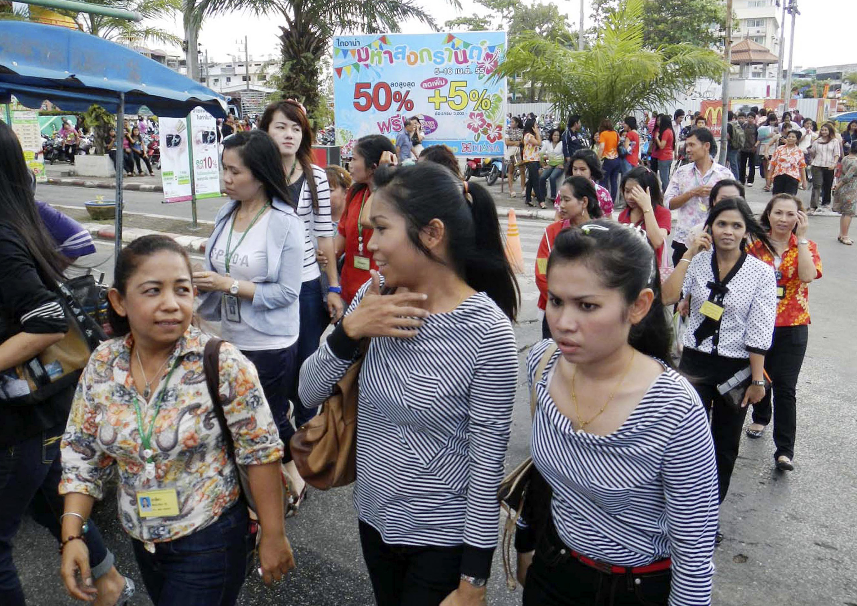 Thailändska kontorsarbetare och boende ute på gatorna efter att ha evakuerats från byggnader i närheten, i Hat Yai, i provinsen Songkhla.