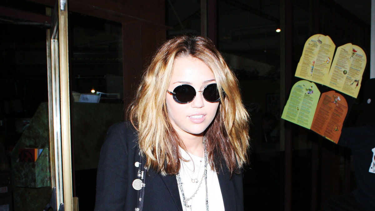 2010: Miley i snygga John Lennon solglasögon.