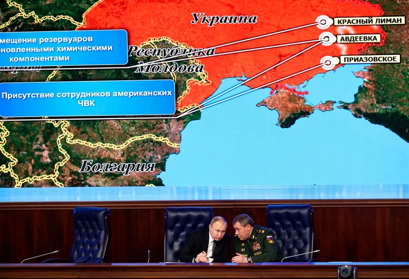 Rysslands president Vladimir Putin i samspråk med den ryska militärens generalstabschef Valerij Gerasimov, vid ett försvarsmöte i Moskva i december. Kartan i bakgrunden påstods då visa posteringar av amerikanska legosoldater i östra Ukraina. Arkivbild.