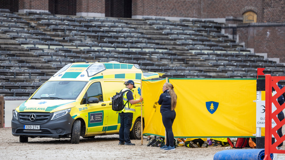 Ryttaren Peder Fredricson bakom insynsskydd efter olyckan på Stockholms stadion.