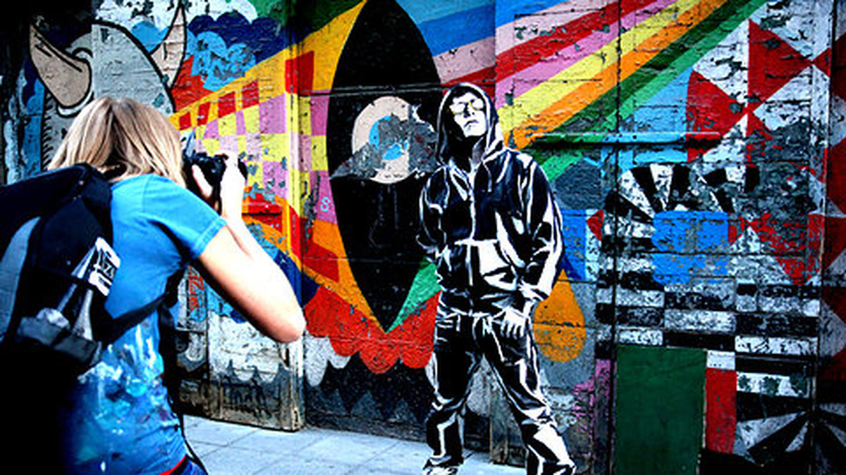 Den här killen har hon målat i svartvitt och ställt honom framför en graffitivägg. 