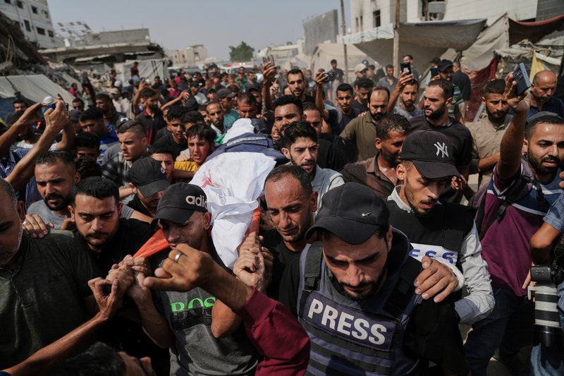 Palestinians carry the body of Al Jazeera correspondent Anas al-Sharif, who, along with other journalists, was killed in an Israeli airstrike, during his funeral outside Gaza City's Shifa hospital complex, Monday, Aug. 11, 2025. (AP Photo/Jehad Alshrafi) KH105