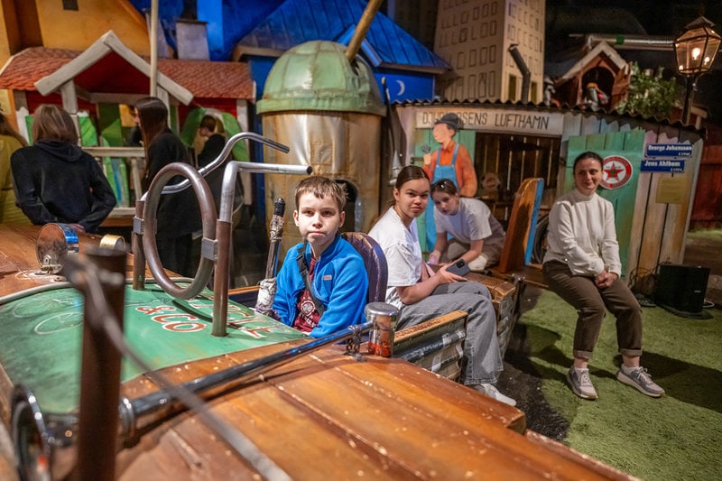 I rummet "Sagotorget" på Junibacken får barnen möta olika karaktärer, däribland Karlsson på taket, Mamma Mu och Mulle Meck. Sasja från Ukraina testar ett flygplan.