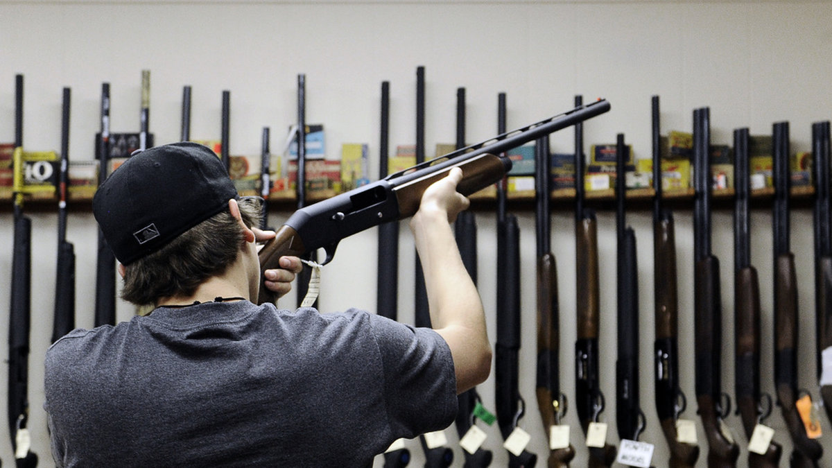 En man känner på ett hagelgevär i en vapenbutik i Texas. Arkivbild.