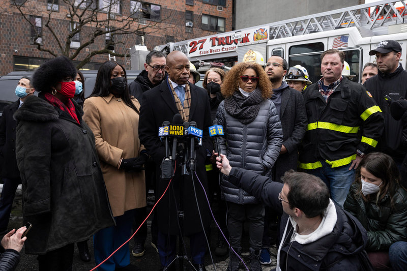 Borgmästare Eric Adams talar inför ett pressuppbåd framför byggnaden i Bronx.