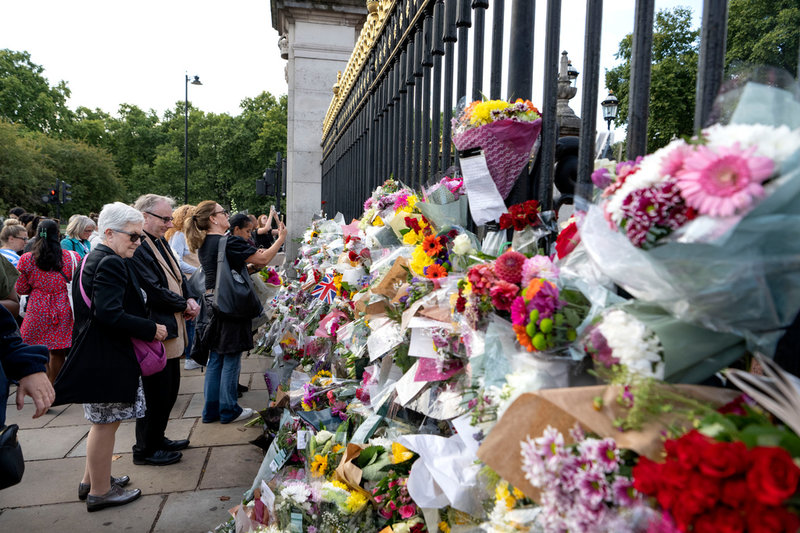 Människor lämnar blommor utanför Buckingham Palace i London med anledning av drottning Elizabeth bortgång.