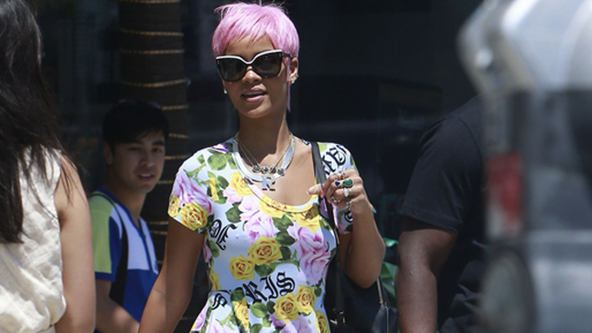 Rihanna i rosa hår och blommig klänning på stan. 