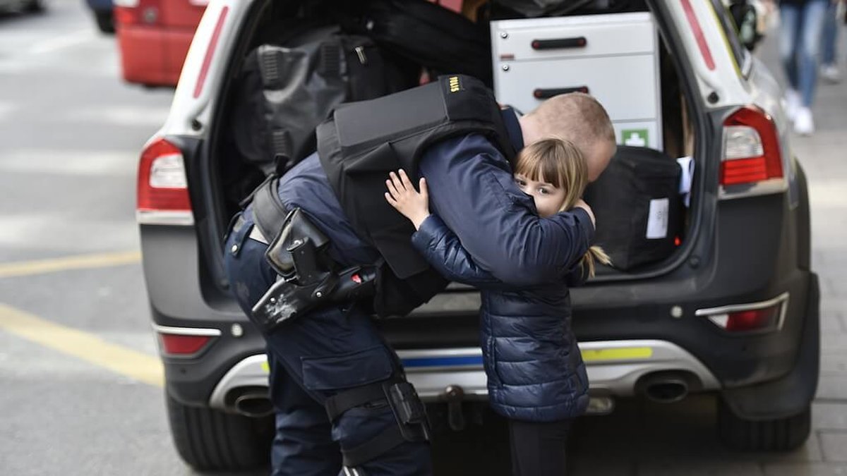 En polis ger en liten flicka en kram i samband med manifestationen. 