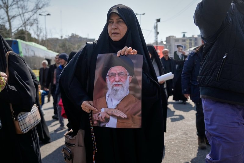 En kvinna med ett porträtt av Irans döde högste ledare, ayatolla Ali Khamenei. Bilden togs i Teheran i fredags.