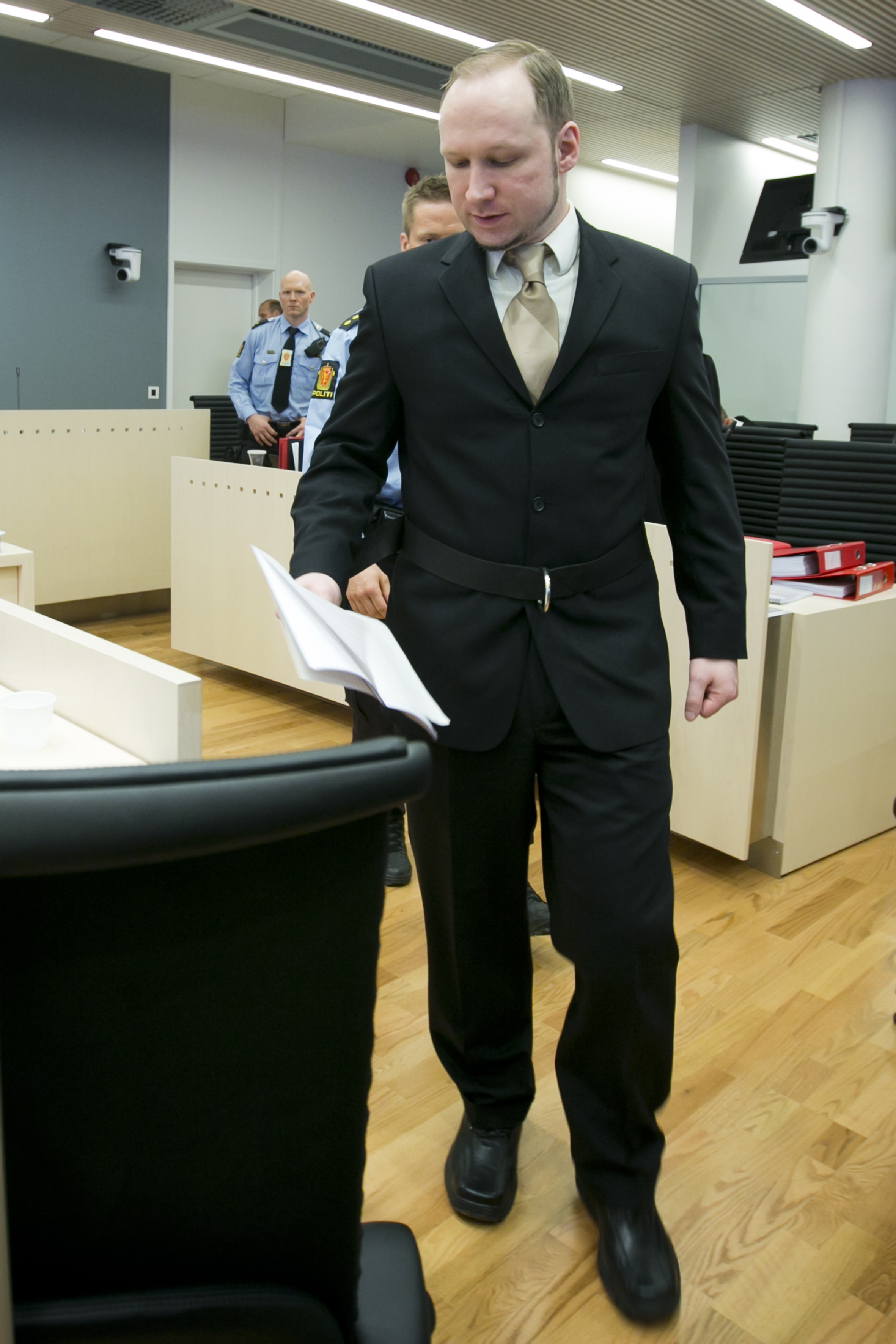 Breivik på väg till vittnesbåset med sin nyskrivna text i handen.