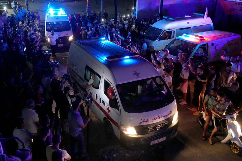 Ambulanser från libanesiska Röda korset transporterar avlidna som drunknade över gränsen, från Syrien till Libanon, på fredagen.