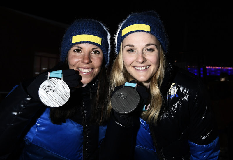 Charlotte Kalla (till vänster) med sin nionde och sista OS-medalj. Den tog hon i sprintstafett tillsammans med Stina Nilsson 2018 i Pyeongchang, Sydkorea. Arkivbild.