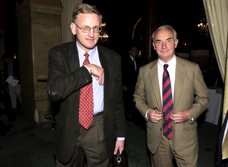 Lundin Oils grundare Adolf Lundin och Carl Bildt, tidigare statsminister och då styrelseledamot i bolaget, på väg in till bolagsstämma på Grand Hotel i Stockholm i maj 2001. 