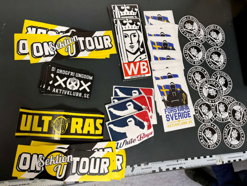 Klistermärken och symboler från nazistiska Aktivklubb Sverige och Stockholmsavdelningen White Boys hittades i en väska som en av de åtalade männen hade på sig när han greps. Bild från polisens utredning.