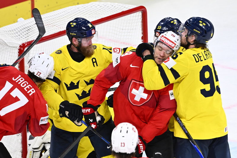 Sveriges Jacob de la Rose tar ett grepp på Schweiz Calvin Thürkauf och i mitten syns Mattias Ekholm.