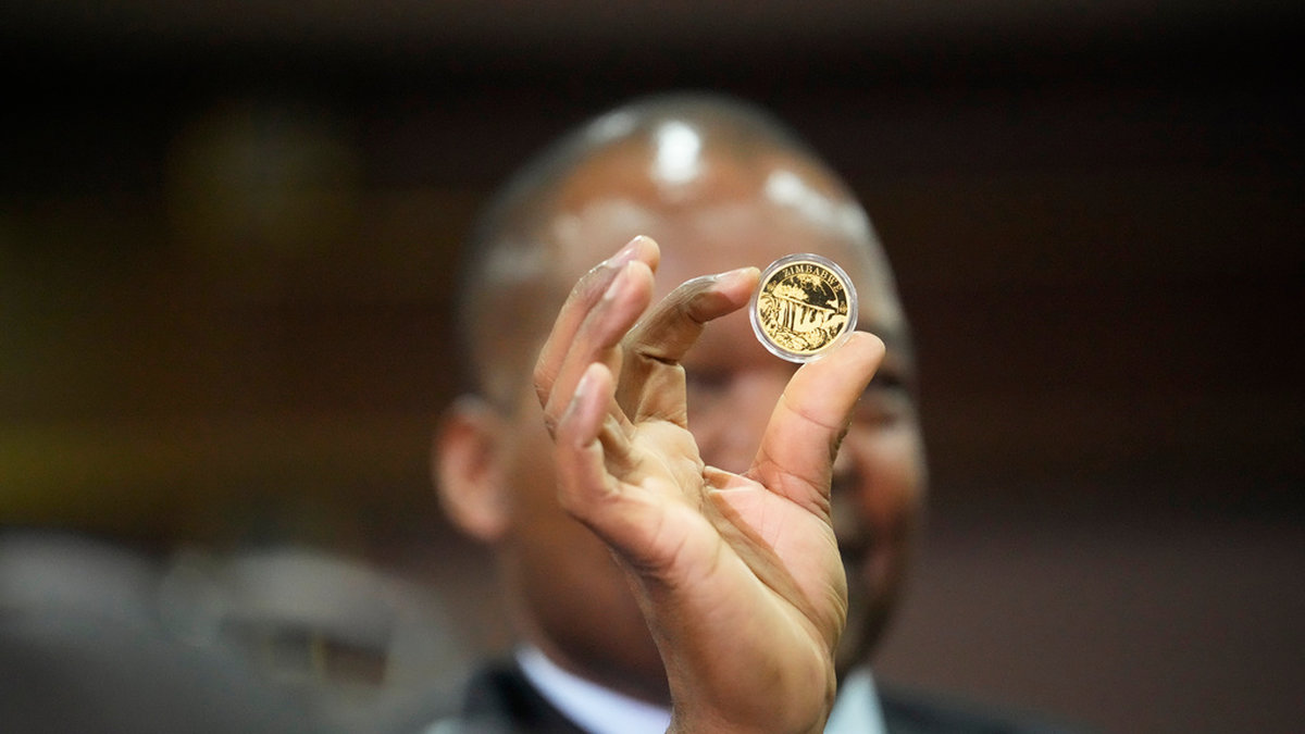 Centralbankschefen John Mangudya visar upp de nya guldmynten i Harare. Bilden är från lanseringen i juli.
