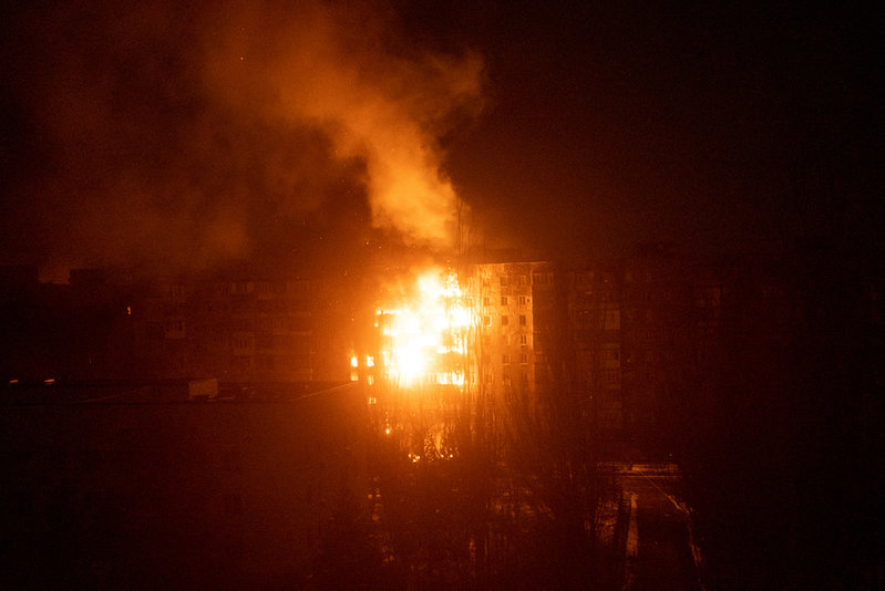 En brand i ett hyreshus efter att det träffats av artillerield i den belägrade staden Mariupol i Ukraina den 11 mars.