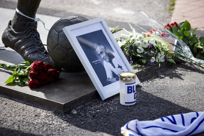 Blommor, en halsduk och ett foto vid statyn av bortgångne fotbollslegendaren Ove Kindvall i Norrköping.