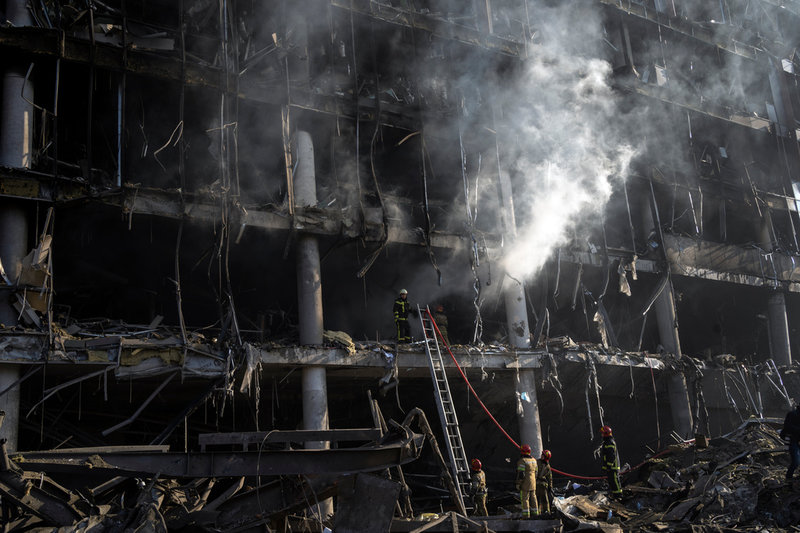 Brandmän vid det köpcenter i Kiev som anfölls av ryska bomber tidigare i veckan.