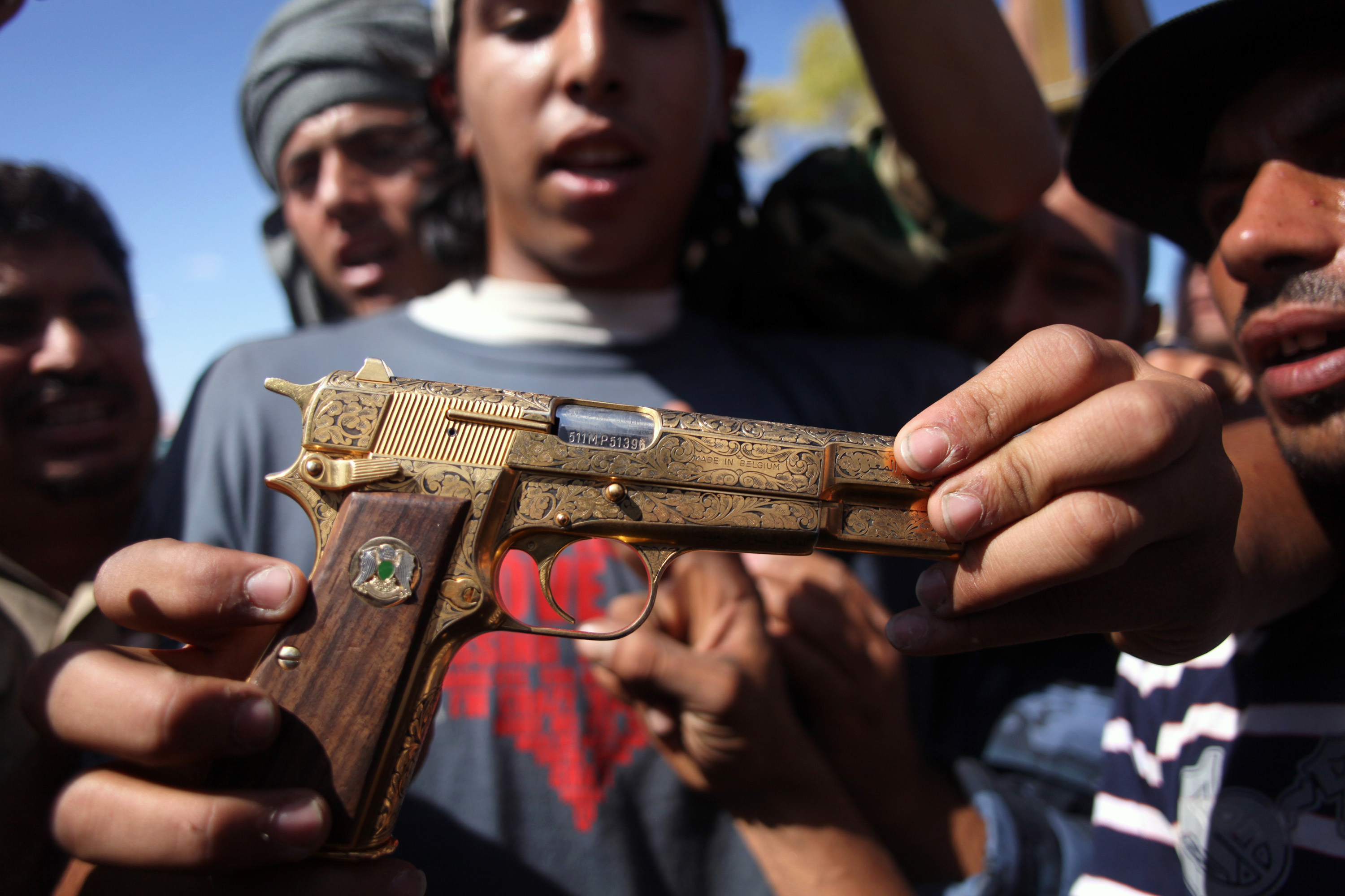 En rebellsoldat håller upp vad han säger är Khaddafis egna pistol.