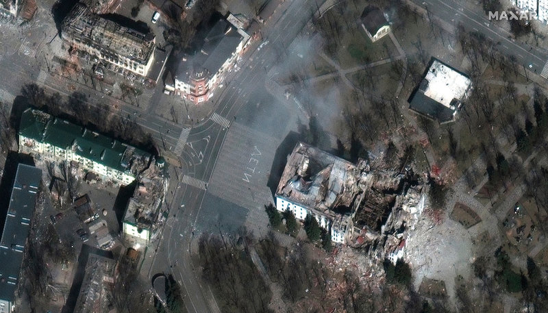 Satellitbild, tagen den 29 mars, som bland annat visar den bombade teatern, nere till höger, i Mariupol. Framför byggnaden står texten 'barn' på ryska.