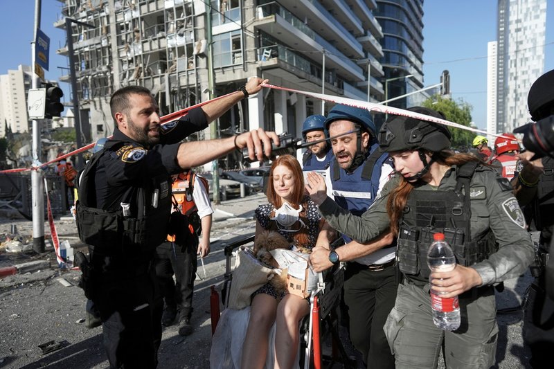 En kvinna evakueras sedan en iransk robot slagit ned i Ramat Gan, Israel på torsdagen.