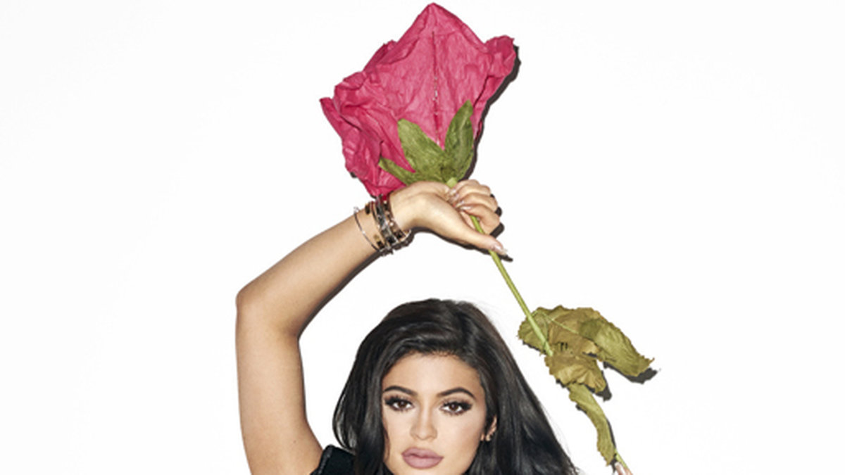 Kylie poserar med en stor ros. 