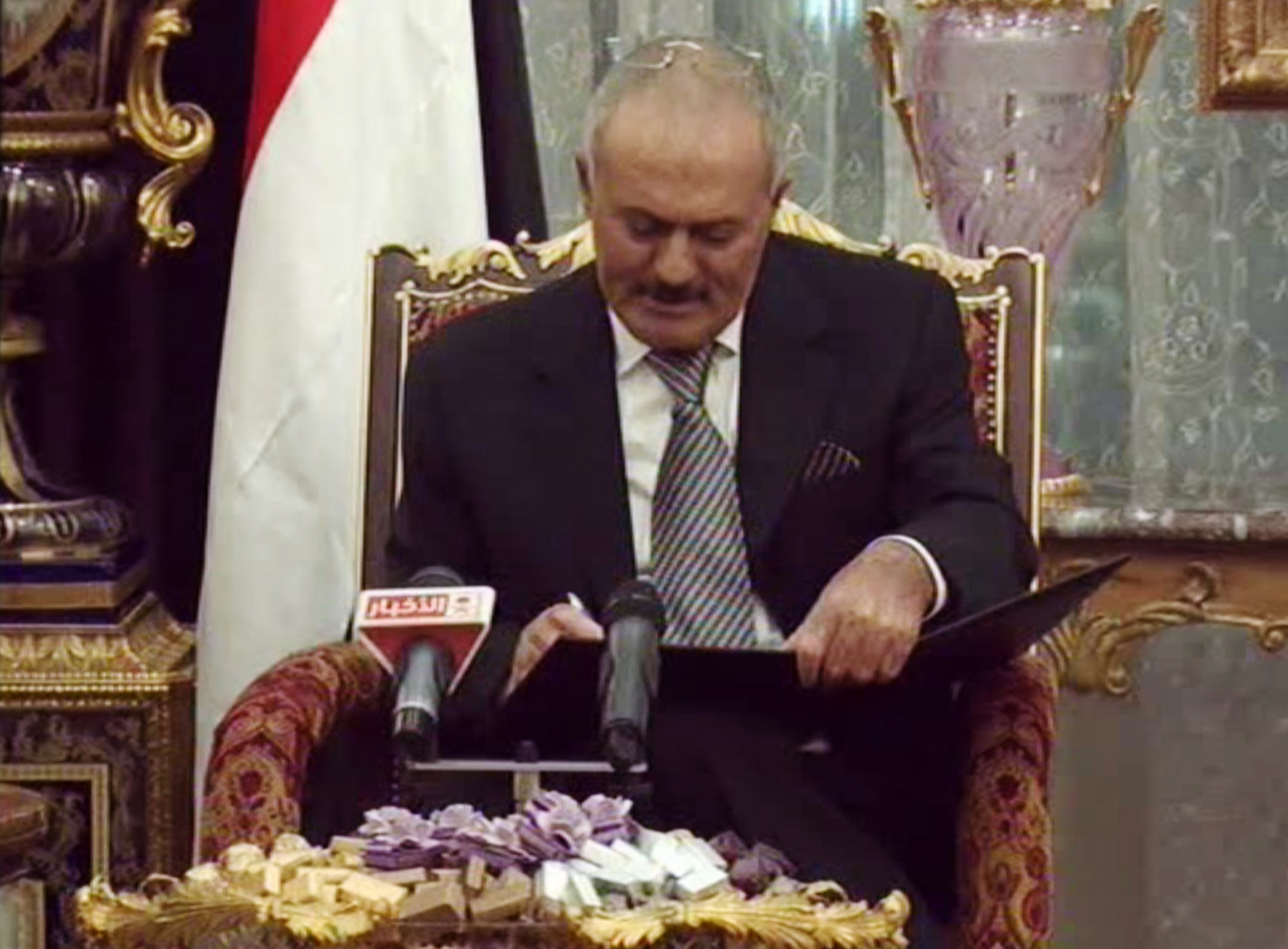 Bilder från den statliga televisionen visar hur Ali Abdullah Saleh skriver under avskedsavtalet.