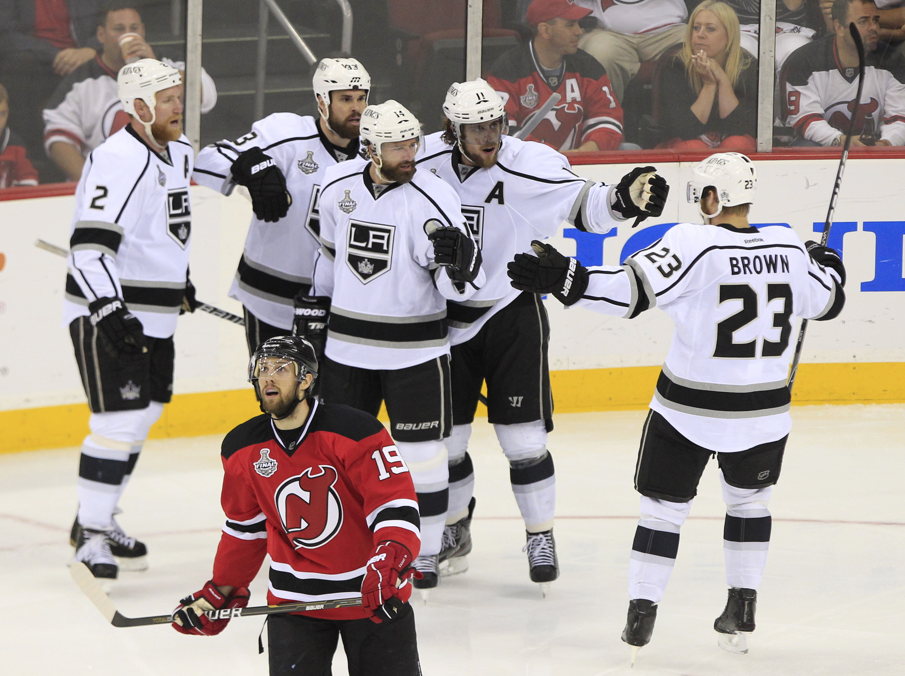 New Jersey Devils Travis Zajac åker förbi Los Angeles Kings Justin Williams och hans jublande lagkamrater. New Jersey Devils Travis Zajac åker förbi Los Angeles Kings Justin Williams och hans jublande lagkamrater.