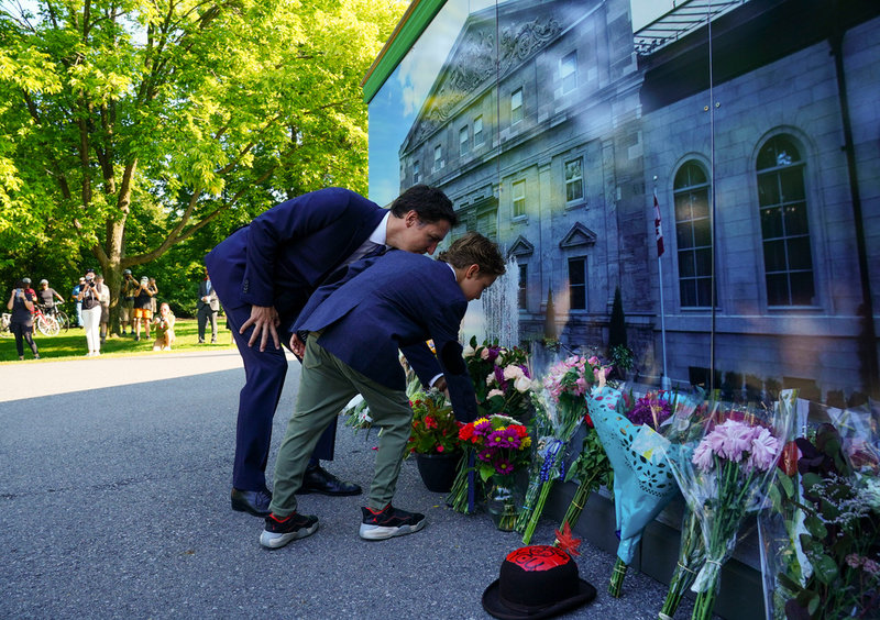 Kanadas premiärminister Justin Trudeau och hans son Hadrien lägger ner blommor vid Rideau Hall i Otttawa.