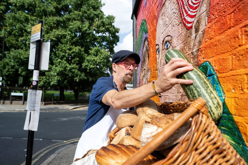 Ray Barron-Woolford placerar ut en korg med gratis bröd utanför matbanken i Lewisham.