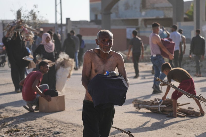 Palestinier med nödhjälp utdelad av GHF i Rafah i södra Gaza i maj.