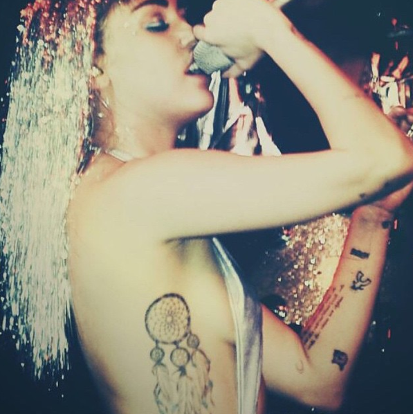 Miley visar upp sin tatuering. Miley visar upp sin tatuering.