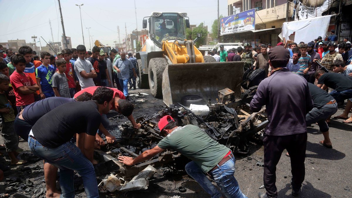 Irakierna städar bort efter bilbomben.
