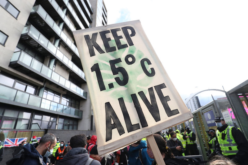 'Håll 1,5 grader vid liv' står det på en skylt som syftar på Parisavtalets temperaturmål, under en demonstration utanför FN:S klimattoppmöte i Glasgow 2021.