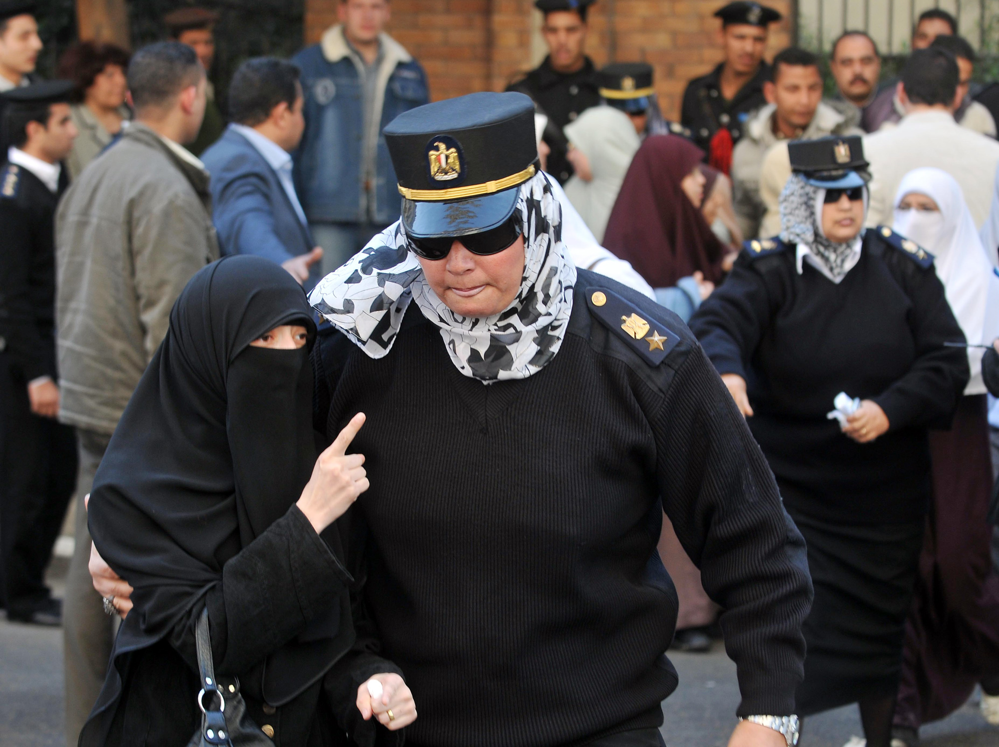 En egyptisk poliskvinna arresterar en beslöjad aktivist i Muslimska brödraskapet.