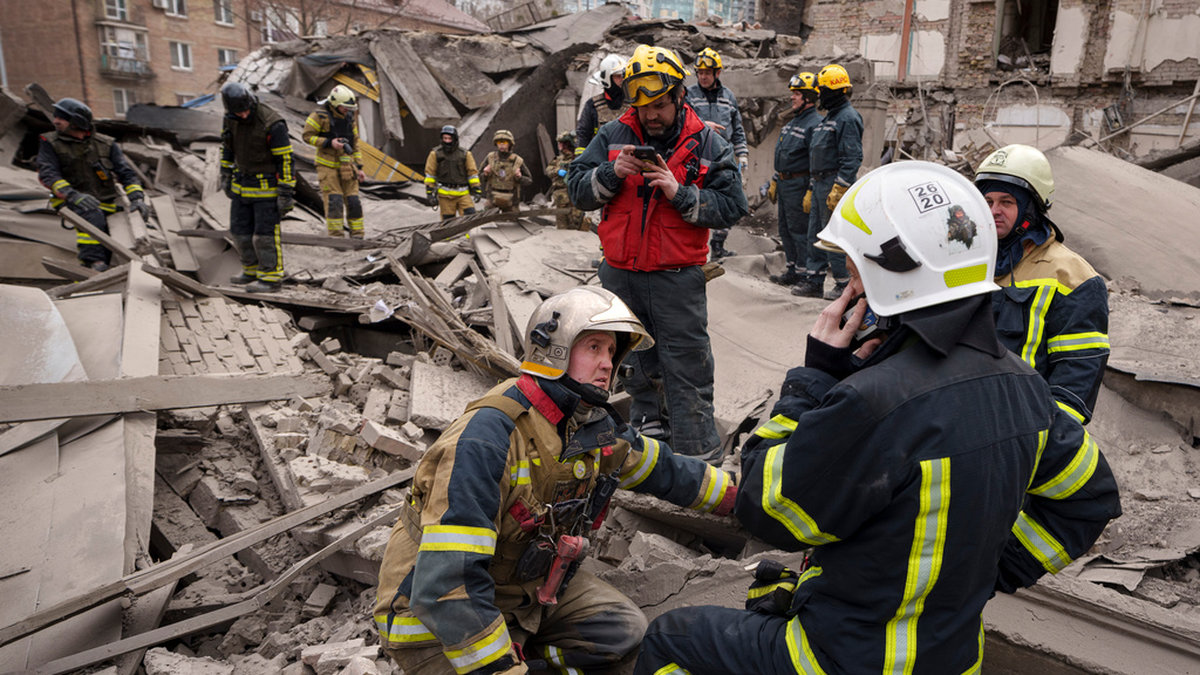 Räddningspersonal inspekterar skadorna på en byggnad i stadsdelen Petjerskyj i Kiev efter ett ryskt flygangrepp den 25 mars. Arkivbild.