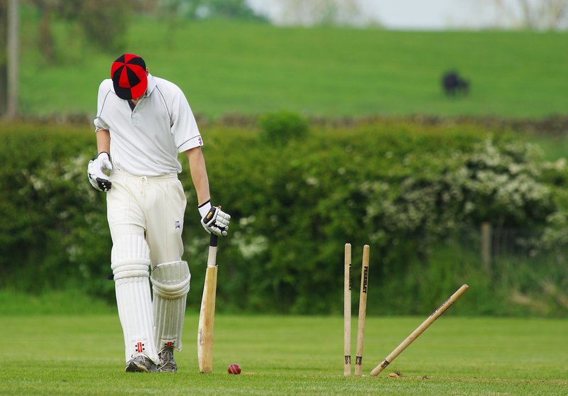 Cricket played on a field. Cricket played on a field.