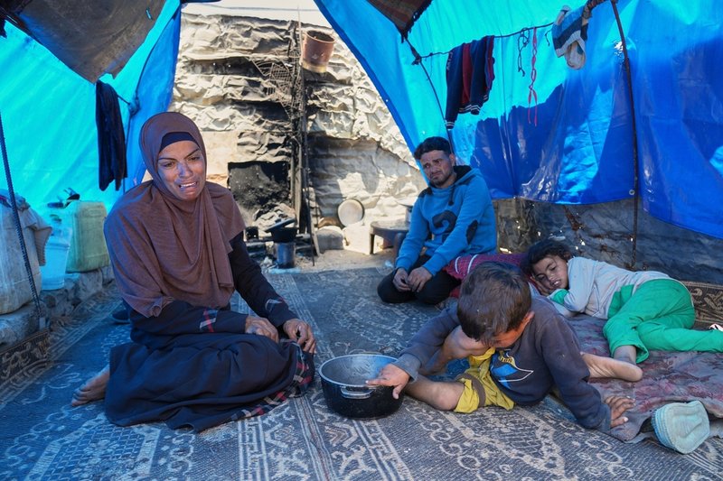 Palestinska Ward Nar, hennes man Mohammed Zaharna och barnen Raed och Sally i Khan Yunis. Bild tagen efter att familjen tvingats återvända tomhänta till sitt tält från en matutdelning i förra veckan.