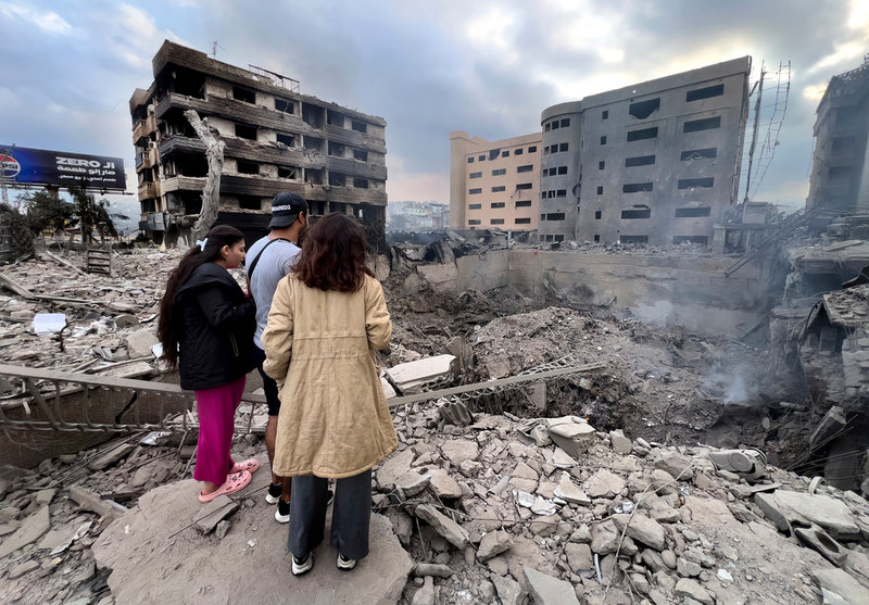 Libaneser tittar på förödelsen efter israeliska luftanfall mot al-Dahiya i södra Beirut.