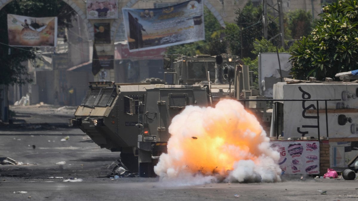 En bomb kastad av en palestinier exploderar intill en israelisk stridsvagn i Jenin.