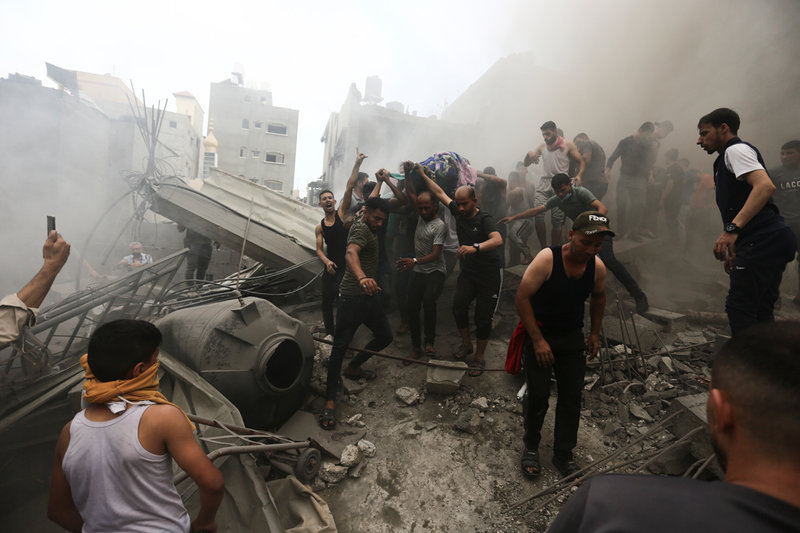 Palestinier bär undan en död person som har hittats i bråten efter att en byggnad i flyktinglägret Jabaliyya har bombats. Bilden togs den 9 oktober. Arkivbild.