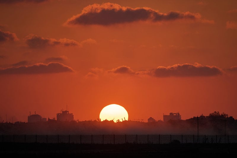 Solen går ner över raserade byggnader i Gazaremsan. Bild tagen från södra Israel i onsdags.