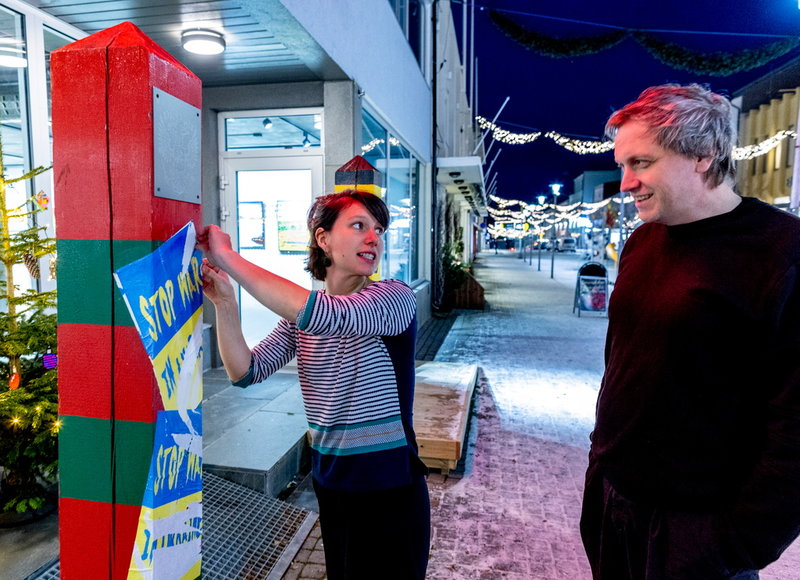 Två gränsstolpar från den norsk-ryska gränsen står placerade utanför kulturkollektivet Pikene på broens utställningslokal. På den ryska stolpen har Astrid Fadnes och Evgeny Goman satt upp antikrigsaffischer – men någon river hela tiden ner dem.